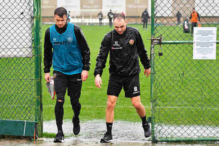 Patschnass! Philip Heise (l.) und Rico Benatelli verlassen den Trainingsplatz.