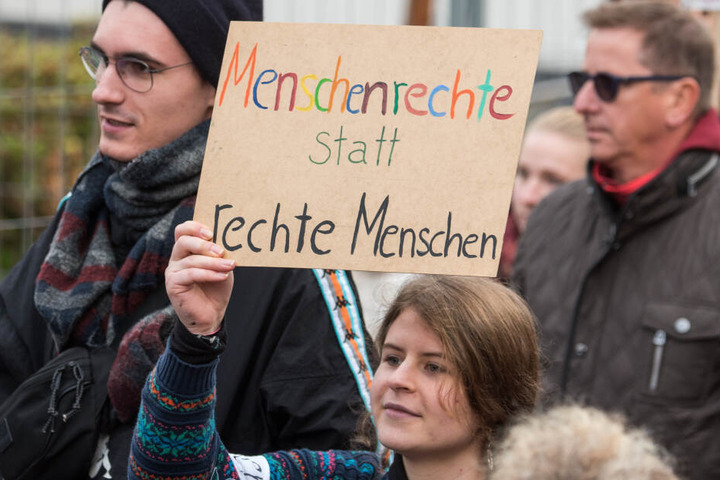 Teilnehmer einer Demonstration gegen Neonazis und rechte Gewaltziehen durch die Innenstadt und halten ein Schild mit der Aufschrift "Menschenrechte statt rechte Menschen". (Symbolbild)