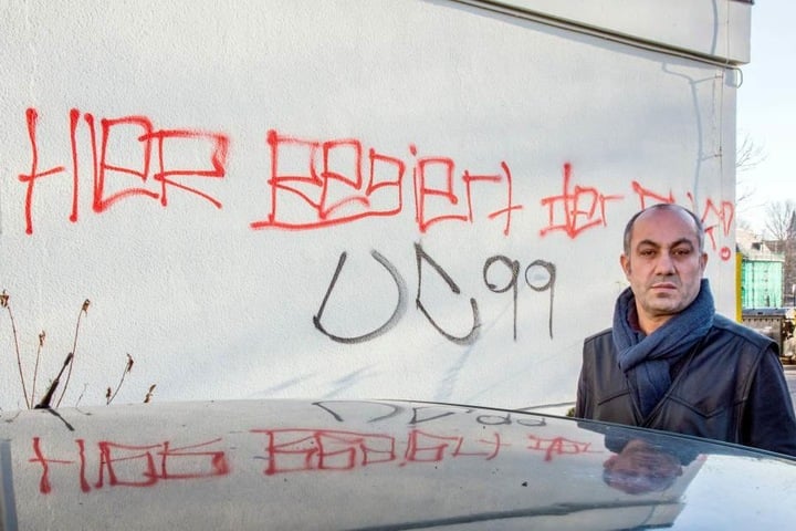 Bäcker Yavuz Kaya (52) vor der beschmierten Fassade seiner Bäckerei.