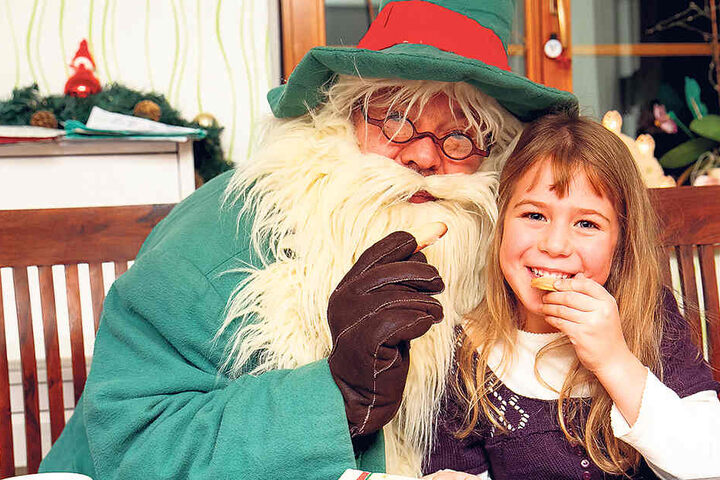 Als Räuchermann nascht Peter Splitt mit Pfefferkuchenprinzessin Miriam (6) Plätzchen.