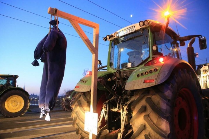 Ein Bauer bzw. die Landwirtschaft hängt hier symbolisch am Galgen.