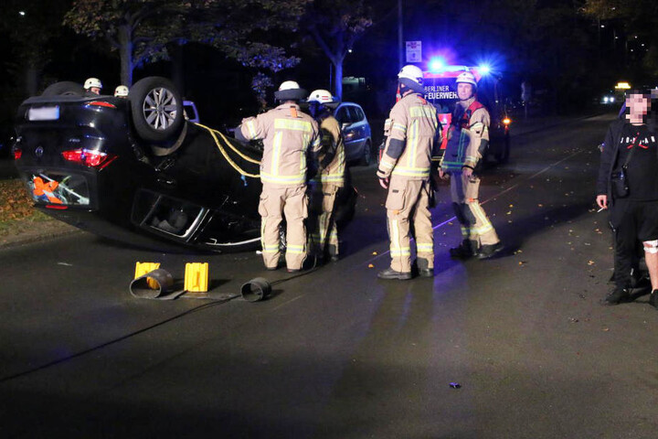 Mit verbundenem Knie raucht der junge Unfall-Fahrer (re.) erstmal eine Kippe auf den Schreck.