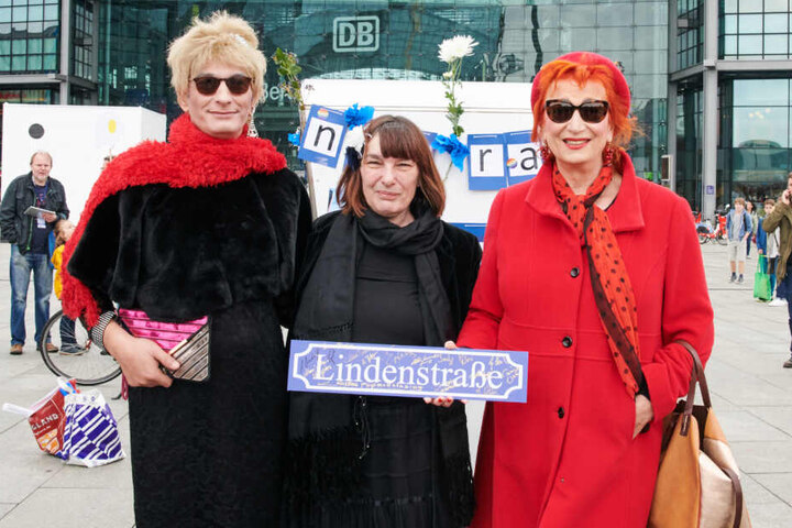 Die Schauspielerin Zazie De Paris (r.) und anderen Demonstranten halten vor dem Hauptbahnhof ein "Lindenstraße"-Schild