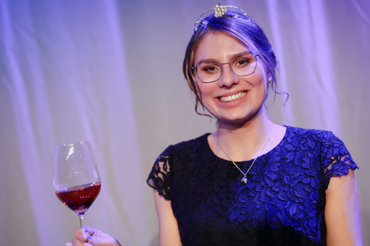 Die baden-württembergische neue Weinkönigin Tamara Elbl hält ein Glas Wein in der Hand.