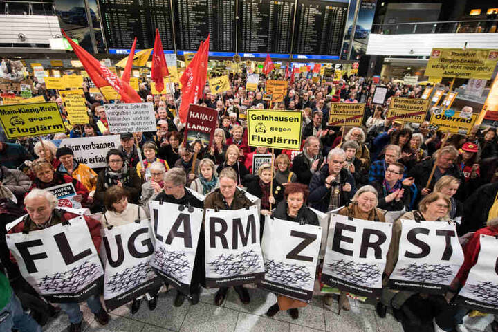 Immer wieder wird gegen Fluglärm demonstriert. Hier stehen Kundgebungsteilnehmer 30.01.2017 mit einem Fluglärm-Plakat im Terminal A des Frankfurter Flughafens.