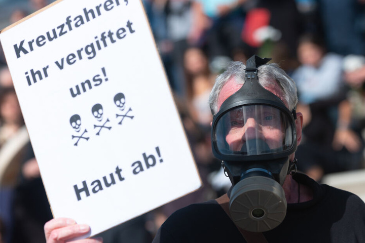 Ein Mann posiert mit einer Gasmaske und einem Protestplakat während einer Protestaktion der Gruppe "Extinction Rebellion" in Hamburg.