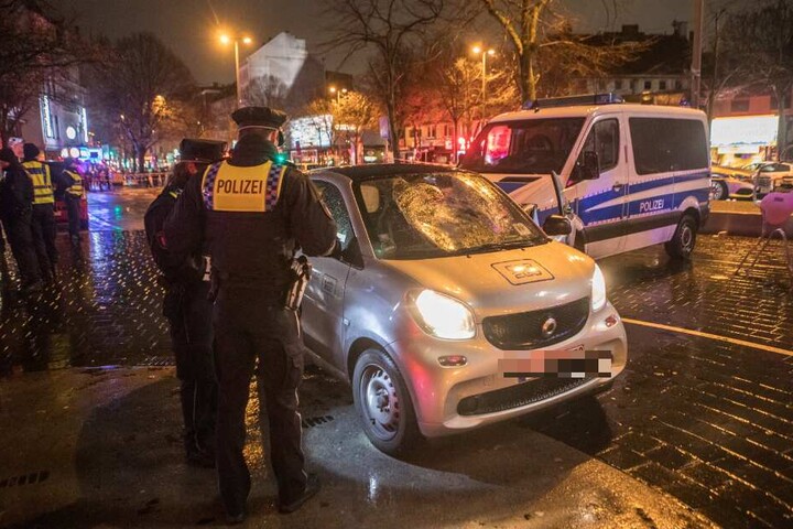 Polizisten begutachten den zerstörten Unfallwagen.