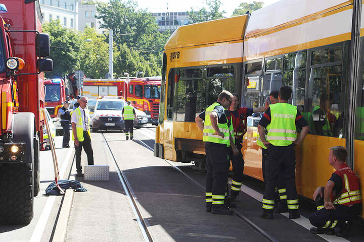 Mitarbeiter der Feuerwehr begutachten die aus den Gleisen gesprungene Bahn.