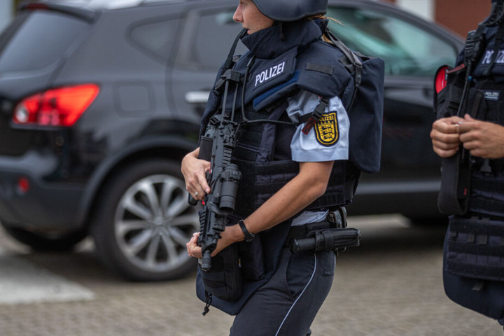 Zu sehen ist eine Polizistin mit Maschinengewehr am Einsatzort.