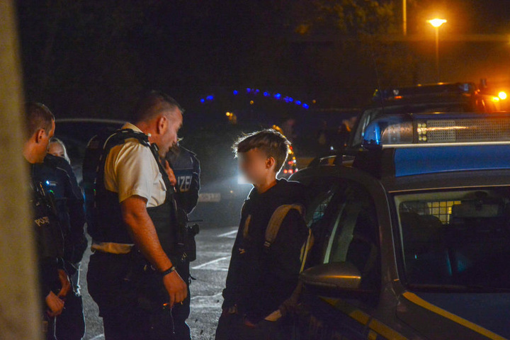 Polizeibeamte weisen einen der Jugendlichen zurecht.