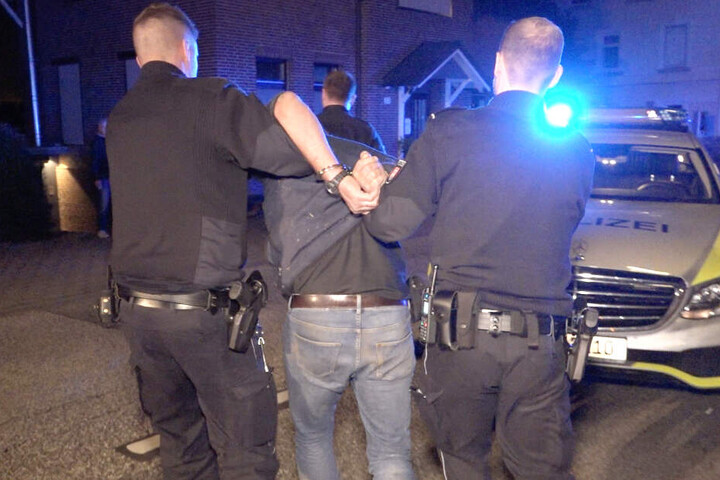 Polizisten haben dem Ersthelfer Handschellen angelegt und führen ihn ab.