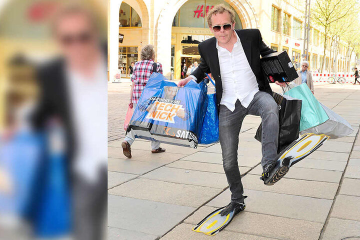 Schauspieler Felx Voigt (47) stapft mit Flossen und Einkaufstzaschen durch die City.