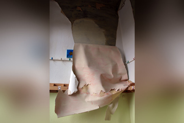 Im Erdgeschoss hängen durchtränkte Tapeten von den Wänden.