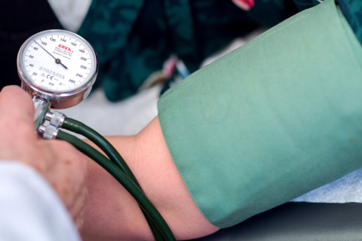 Ein Arzt misst den Blutdruck eines Patienten. (Symbolbild)