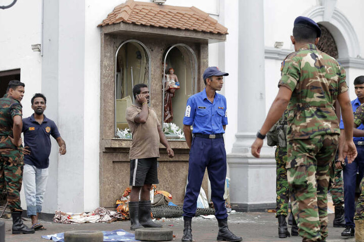Einsatzkräfte stehen nach einer Explosion vor dem St. Anthony's Shrine in Colombo.