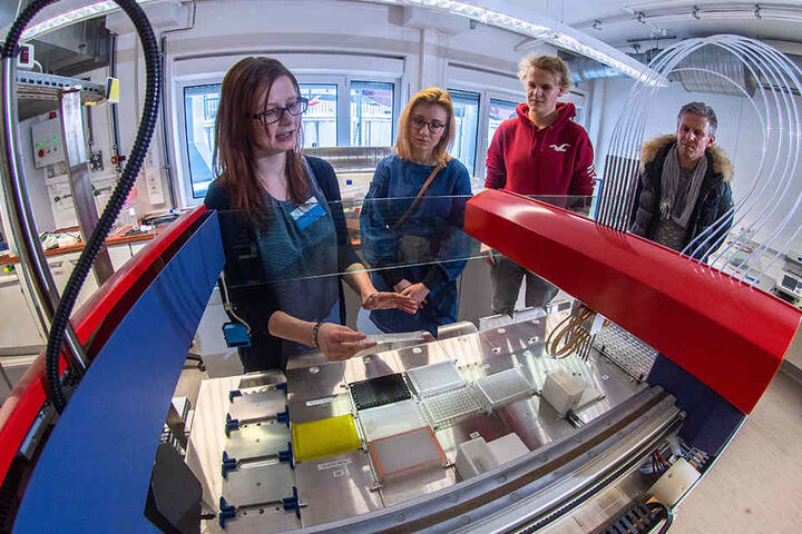 Im Biotechnologie-Labor der HS Mittweida erklärt Dominique Tuch (30, l.) Jessica Kurucz (18), ihrem Vater Jörg Poetzsch (49) und Sören Tara (18) einen Roboter.