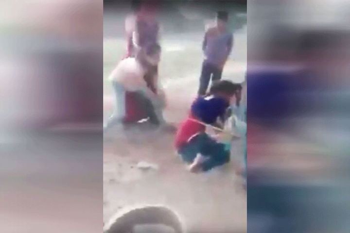 Eine Frau schlägt auf das Opfer ein.