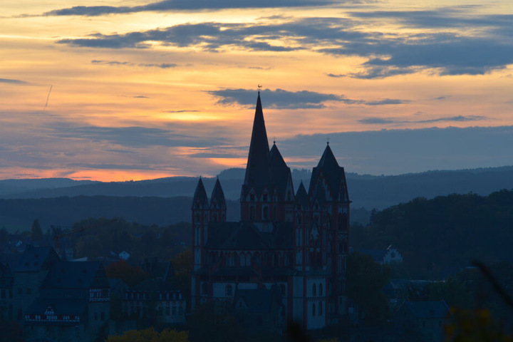 Die Sonne geht hinter dem Limburger Dom unter.