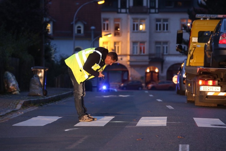 Ein Ermittler sucht mit einer Taschenlampe nach Spuren des schrecklichen Unfalls.