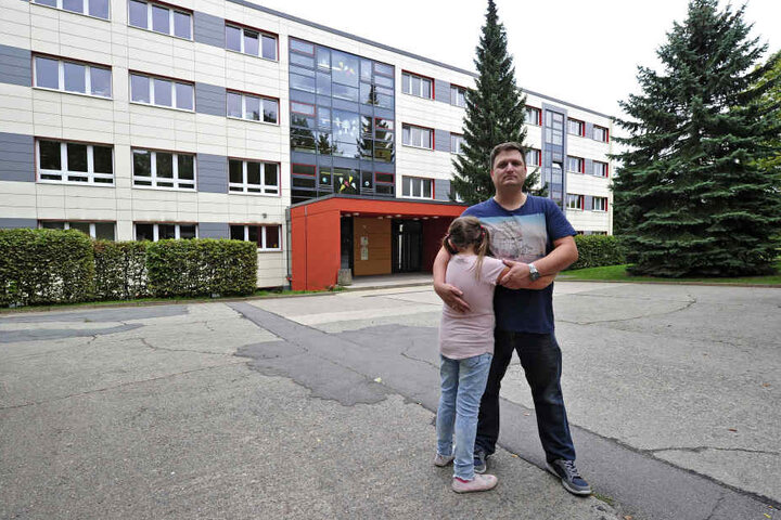 Andreas Lindner (41) und seine Tochter vor der Charles-Darwin-Grundschule. Hier soll es auf dem Weg zum Hort zu der Bedrohung gekommen sein.