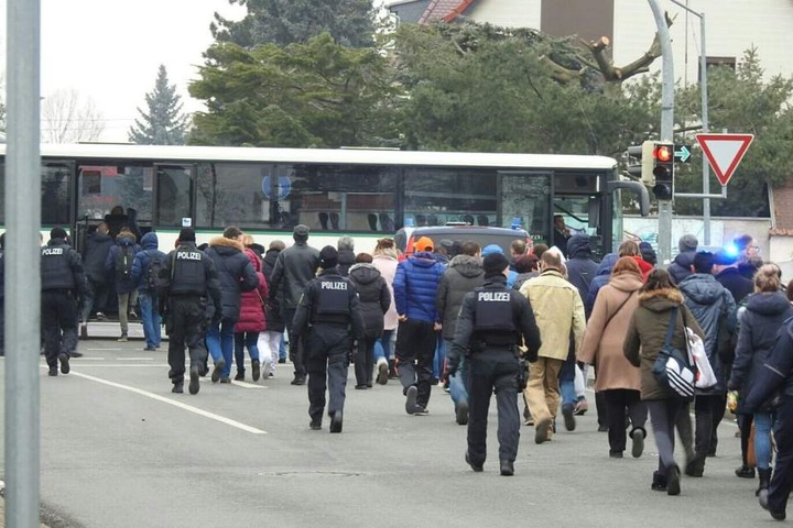 Die Schüler werden unter Begleitung der Polizei zu den Bussen gebracht, die sie in eine Grundschule fahren.