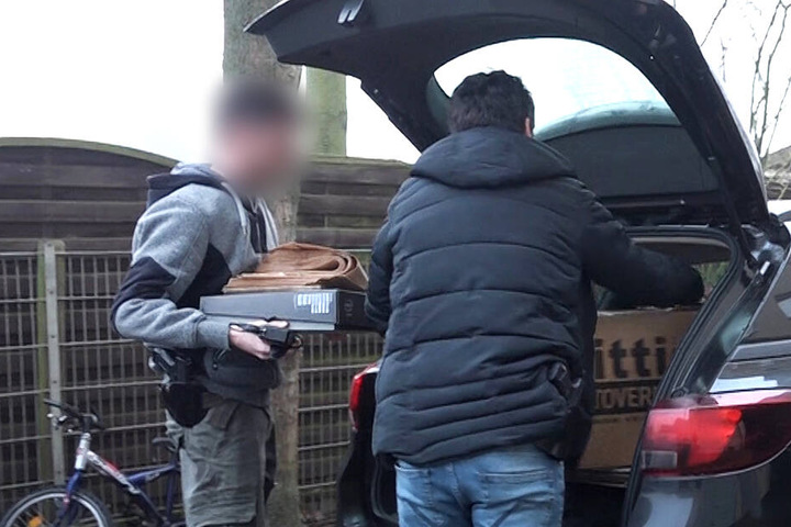 Castrop-Rauxel: Bei einer Razzia laden Zivilermittler der Polizei vor einem Haus Kartons in ein Auto.