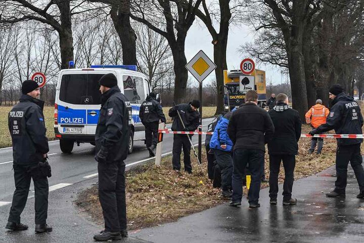 Polizisten stehen an der Stelle, wo zwei ihrer Kollegen starben und suchen nach Spuren.
