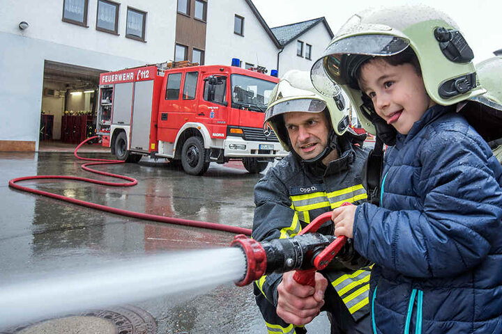 Das macht Spaß! Bilal (5) probierte mit Feuerwehrmann Daniel Opp (38) den Wasserschlauch aus.