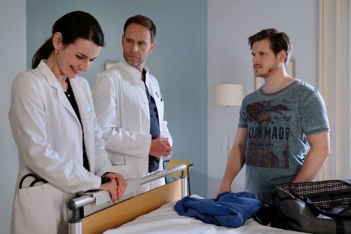 Handwerker Steffen Hartwig (r.) muss wegen einer Veränderung der Bauchschlagader operiert werden. Vorher besteht aber aber auf den Einsatz einer Schamanin, mit deren Hilfe er sich stärken will. Dr. Maria Weber (l.) kann es nicht glauben und bricht in Gelä