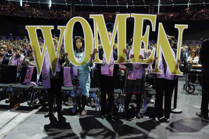 Das Wort "Women" halten Frauen im Tempodrom in Berlin bei einer Veranstaltung "Für Toleranz und Gleichstellung - gegen Fundamentalismus, Fanatismus und Frauenfeindlichkeit" zum Weltfrauentag hoch.