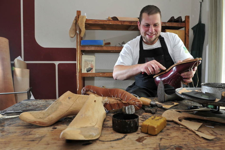 Schuhmacher Sebastian Schulze (32) bringt die Brandsohle in die richtige Form.