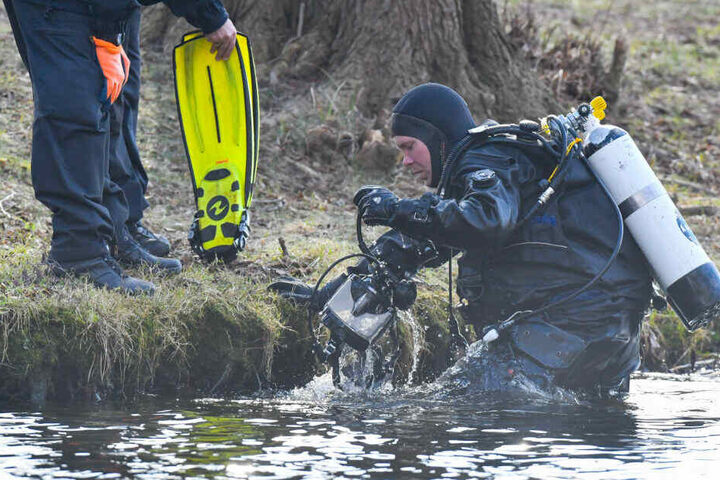 Ein Polizeitaucher kommt aus dem Wasser des Storkower Sees.