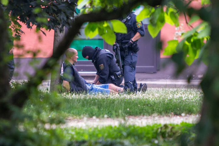 Nach der Schießerei fixieren mit Maschinenpistolen bewaffnete Polizisten einen Rocker der Hells Angels.