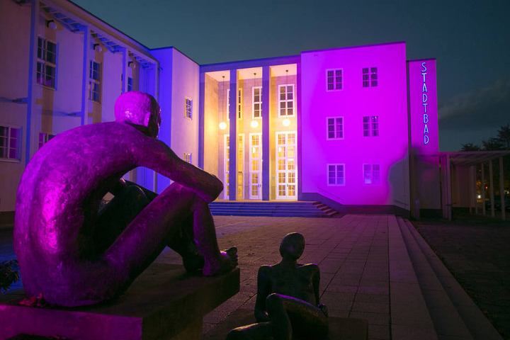 Das im nüchternen Bauhausstil errichtete Stadtbad bunt angeleuchtet.