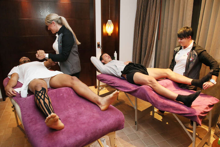 Die Physiotherapeutinnen Nadine Dörfel (l.) und Marie Koch bei der Arbeit. Sie kneten die Muskel von Malcolm Cacutalua und Dominik Wydra wieder weich. Meist geht ihre Schicht bis 23.30 Uhr.