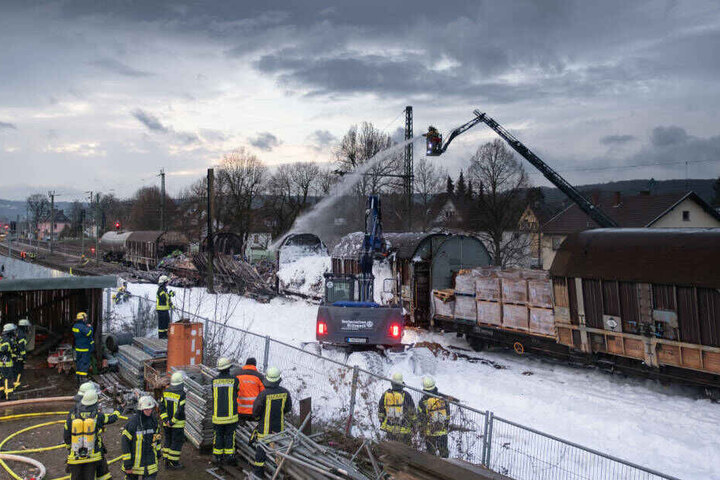 Ein Bagger des Technischer Hilfswerkes beseitigt Trümmer nach dem Brand der drei Güterwaggons.