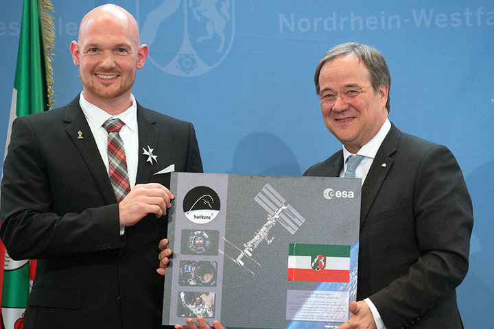 Alexander Gerst überreicht dem Ministerpräsidenten seine Weltall-Flagge.