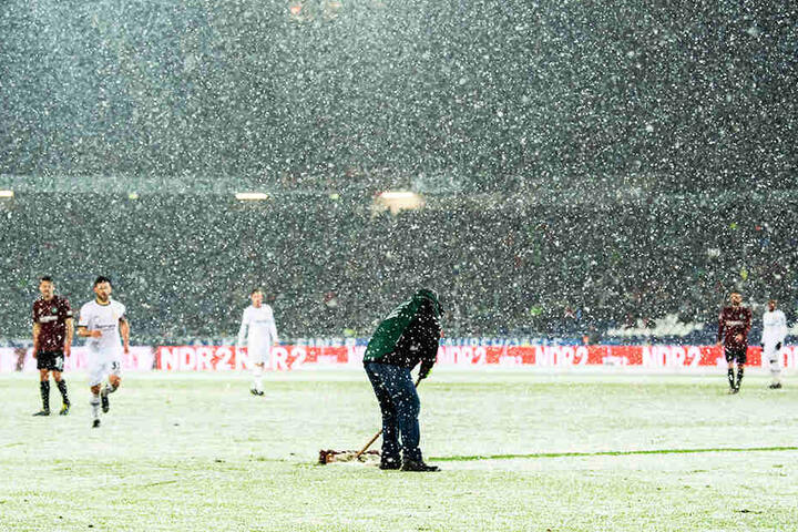 Die Helfer von Hannover 96 sind immer wieder im Einsatz, können dem starken Schneefall aber nur wenig entgegensetzen.