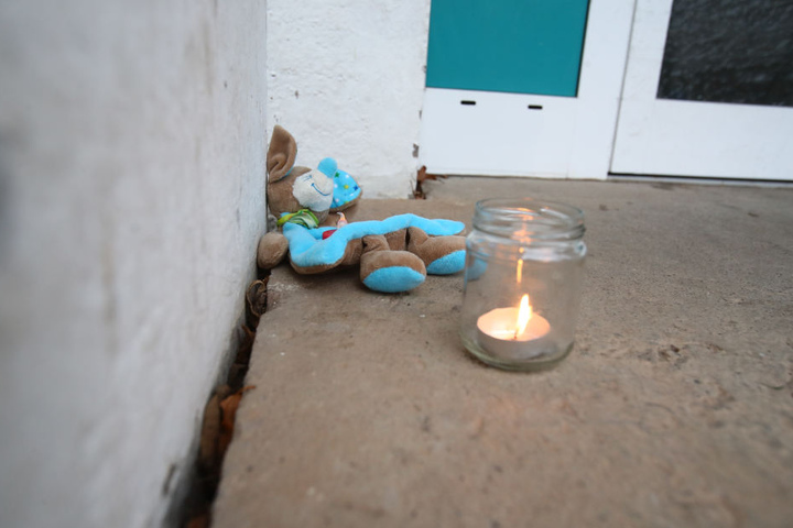Vor dem Hauseingang haben Nachbarn zum Gedenken an die Toten Kerzen und Kuscheltiere abgelegt.