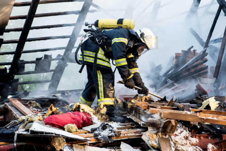 Ein Feuerwehrmann sucht im zerstörten Haus nach dem Vermissten.