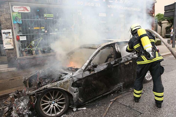 Hier kommt jede Hilfe zu spät: Ein Feuerwehrmann kann in Hamburg nur noch das ausgebrannte Wrack eines Autos löschen.