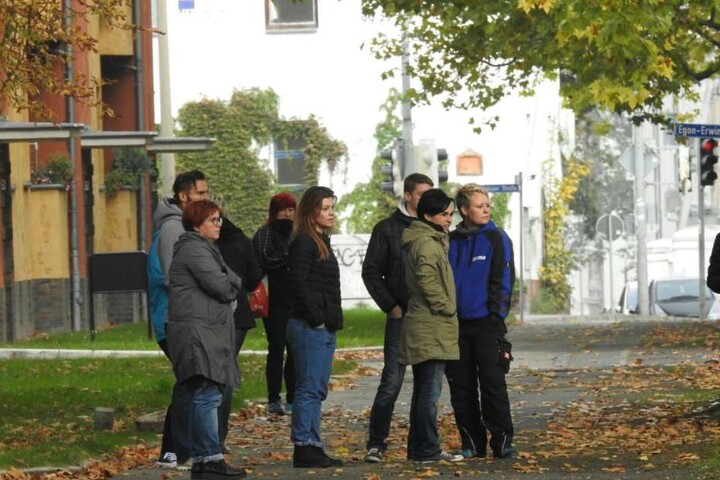 Besorgte Eltern müssen tatenlos vor der abgesperrten Schule warten.