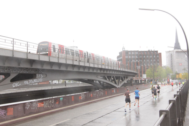 Neben der Linie U3 am Baumwall kämpfen sich die Läufer durch den Regen.