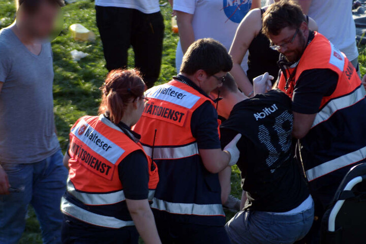 Sanitäter versorgen einen kollabierten Jugendlichen.