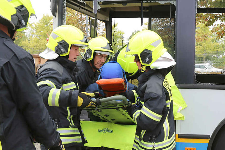 Vorsichtig heben die Feuerwehrleute den Verletzten aus dem Bus.