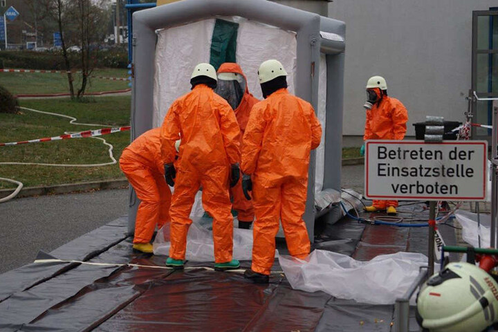 Einsatzkräfte tragen Schutzkleidung: Im Technikbereich soll Schwefelsäure ausgetreten sein.