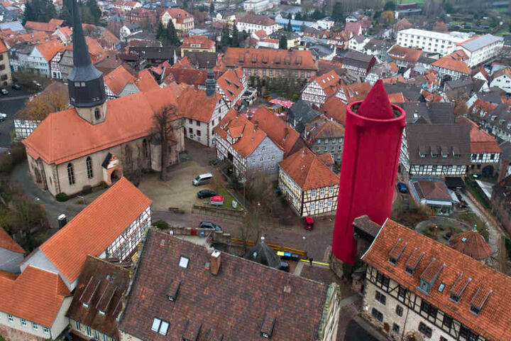 Die rote Kerze überragt alle umstehenden Gebäude.