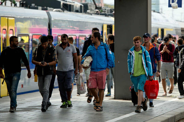 Flüchtlinge, die kurz zuvor mit einem Zug aus Salzburg angekommen sind, gehen auf dem Hauptbahnhof über einen Bahnsteig. (Archivbild)