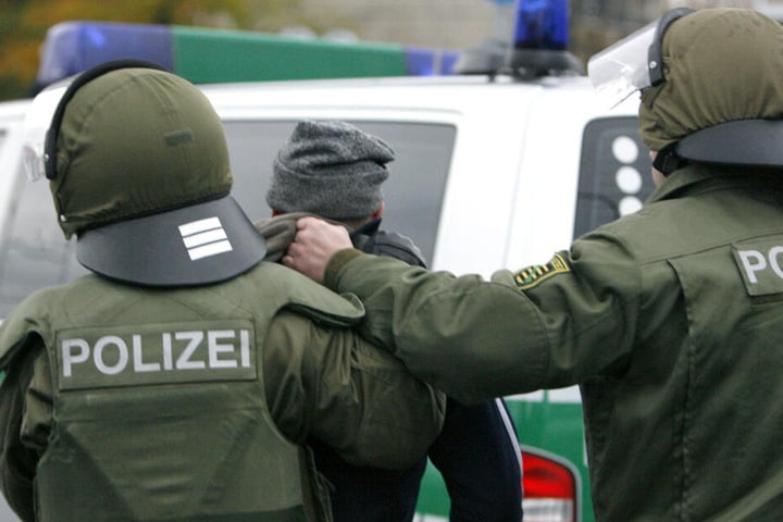 Ein Hooligan wird von zwei Polizisten abgeführt.