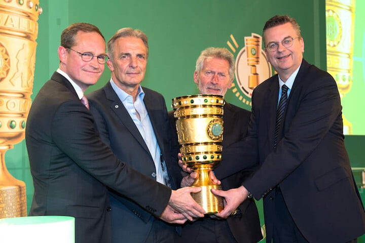 DFB-Boss Reinhard Grindel, Weltmeister Paul Breitner, Eintracht-Legende Charly Körbel und Regierender Bürgermeister Michael Müller (SPD) mit dem begehrten Pott (von li. nach re.).